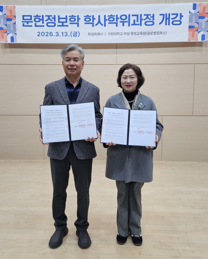 윤미영 도서관정책과장과 가천대 평생교육원 이재원 주임교수가 협약서를 들고 기념촬영을 하고 있다. ⓒ화성시 제공