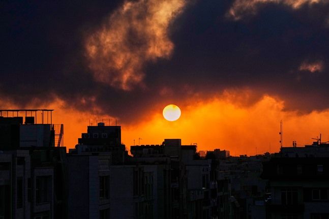 이란 테헤란에서 미국과 이스라엘의 군사 공격 이후 치솟는 연기 뒤로 해가 지고 있다. ⓒAP/뉴시스