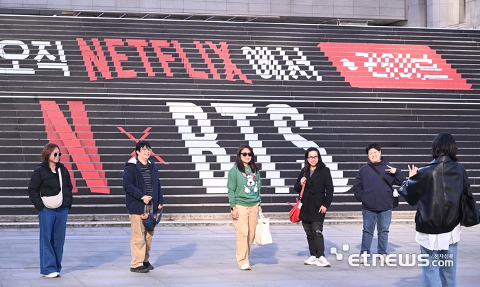 방탄소년단(BTS)의 컴백 라이브: ARIRANG 공연이 오는 21일 서울 광화문 광장에서 진행된다. 이날 공연은 넷플릭스를 통해 전세계로 생중계된다. 시민들이 세종문화회관 계단에 장식된 BTS 공연 홍보물앞에서 사진을 찍고 있다. 박지호기자 jihopress@