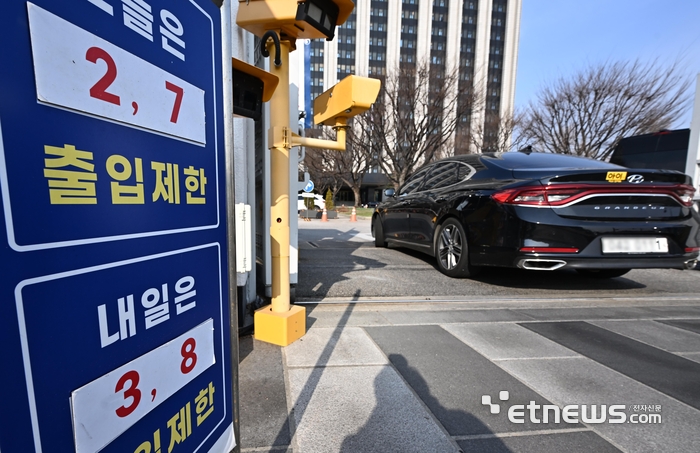 정부가 중동지역 전쟁으로 발생한 에너지 수급 위기에 대비해 공공부문 승용차 5부제(요일제)를 의무적으로 시행한다. 단 전기차나 수소차는 제외한다. 지난 24일 서울 종로구 정부서울청사 출입구에 5부제 안내판에 세워져 있다.  이동근기자 foto@etnews.com