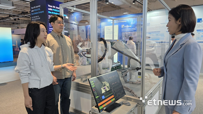 포스코DX AW2026 전시부스에서 관람객들이 로봇자동화 기술이 적용된 스케일브레이커 롤 교체 로봇 시연을 관람하고 있다.