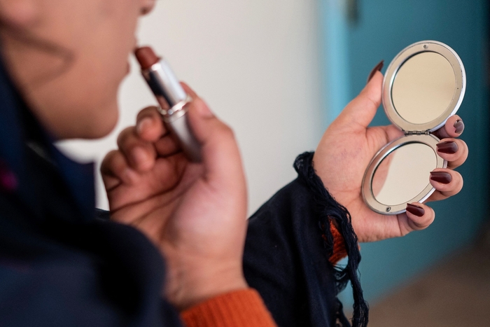 아프가니스탄의 한 병원 의사가 립스틱을 바르고 있다. 아프가니스탄 의대에 여성 입학이 제한되기 전 촬영된 사진. 사진=AFP 연합뉴스