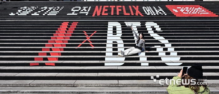 BTS 컴백 라이브 : 아리랑을 이틀 앞둔 19일 서울 종로구 세종문화회관 계단에 마련된 홍보문구 앞에서 관광객이 인증샷을 남기고 있다.  이동근기자 foto@etnews.com