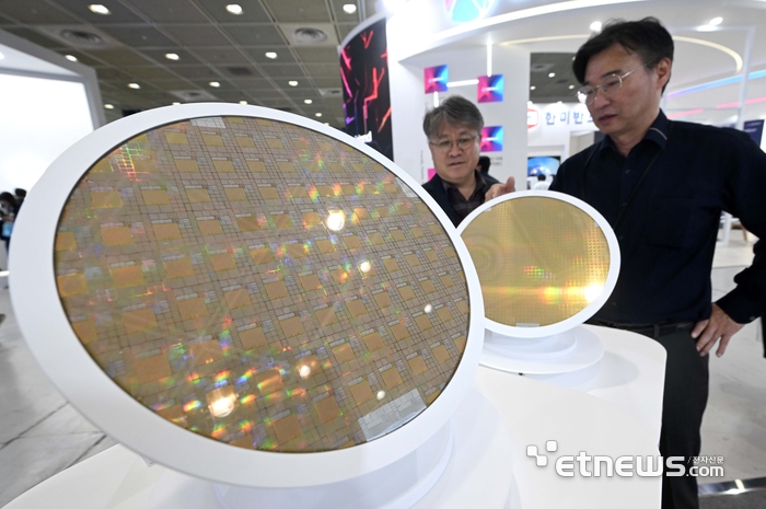 한국반도체산업협회가 주최한 제27회 반도체대전이 22일 서울 강남구 코엑스에서 사흘 일정으로 열렸다. 세미파이브 부스에서 관람객이 반도체 웨이퍼 기술에 대한 설명을 듣고 있다. 김민수기자 mskim@etnews.com