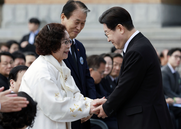 이재명 대통령이 15일 경남 창원시 마산회원구 국립 3·15 민주 묘지에서 열린 제66주년 3·15의거 기념식에서 기념사를 마친 뒤 오무선 유족회장의 손을 잡고 있다. 연합뉴스