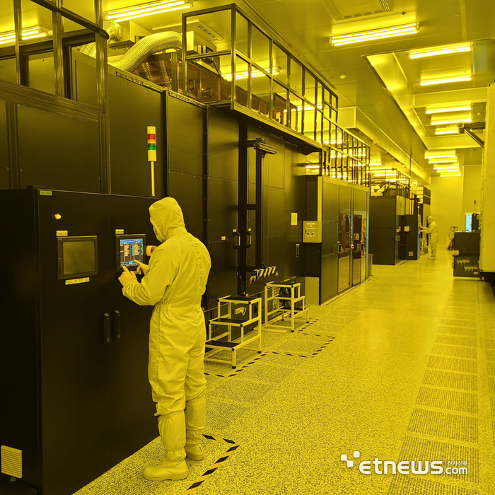 풍원정밀 8.6세대 OLED용 FMM 생산 라인. 엔지니어가 FMM 노광기를 살펴보고 있다.