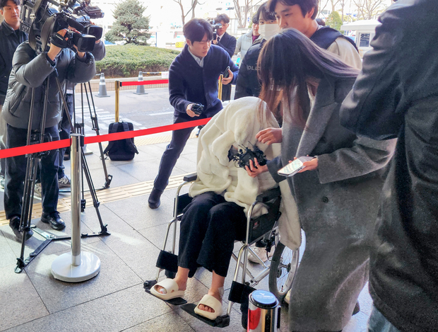 약에 취한 상태로 외제 SUV 차량을 몰고 반포대교를 달리다 한강 둔치로 추락한 운전자 A씨가 27일 서울 마포구 서부지방법원에서 열린 구속 전 피의자 심문(영장실질심사)에 옷으로 얼굴을 가리고 휠체어를 탄 채 출석하고 있다.  연합뉴스