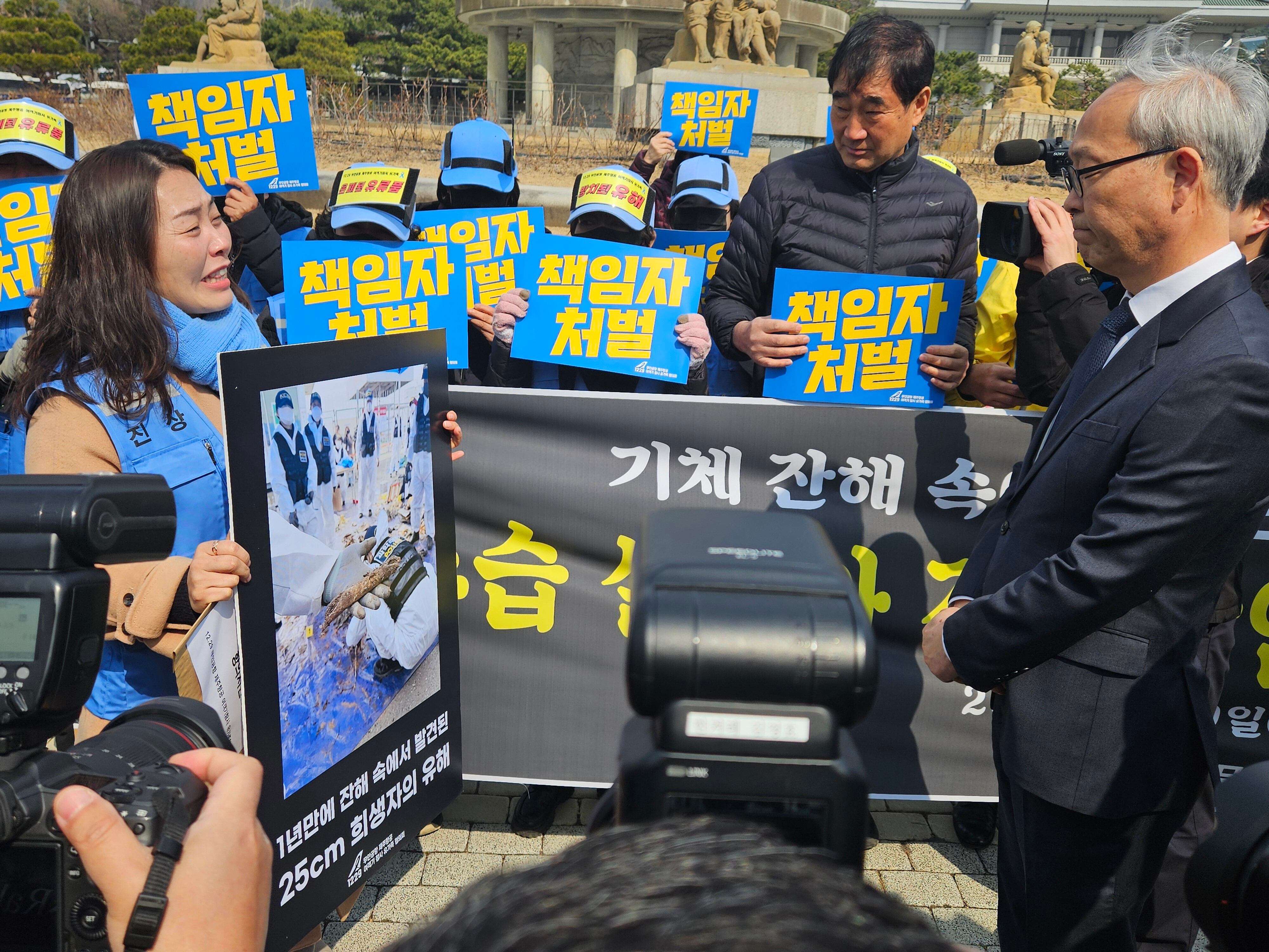 12·29 무안공항 제주항공 여객기 참사 유가족이 9일 오전 서울 종로구 청와대 인근에서 기자회견 후 주진우 대통령실 공공갈등조정비서관에게 항의 서한을 전달하고 있다. /뉴스1