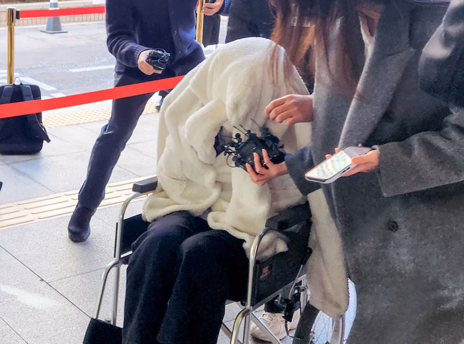 약에 취한 상태로 포르쉐를 몰고 반포대교를 달리다 한강 둔치로 추락한 운전자 A씨가 지난달 27일 서울 마포구 서부지방법원에서 열린 구속 전 피의자 심문(영장실질심사)에 옷으로 얼굴을 가리고 휠체어를 탄 채 출석하고 있는 모습. /연합뉴스