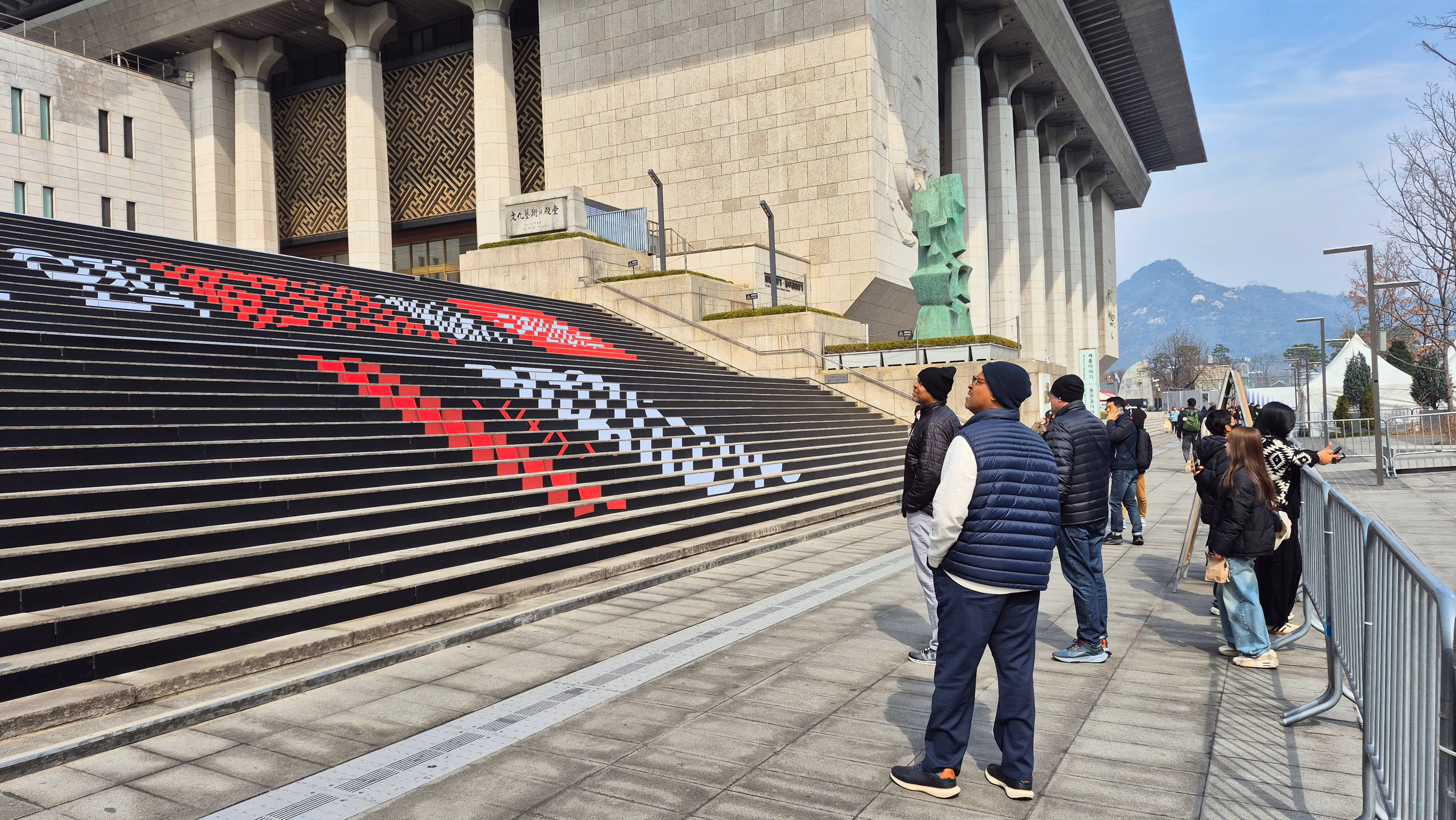 16일 서울 광화문광장을 지나가던 외국인들이 계단에 있는 BTS 컴백 홍보물을 바라보고 있다./임희재 기자