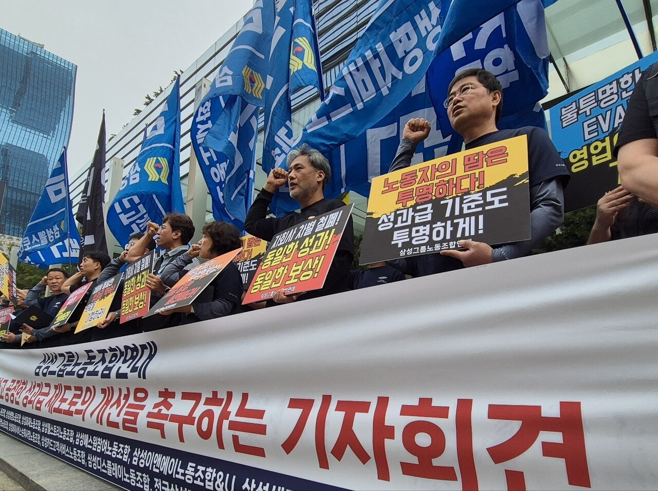 삼성 13개 계열사 연합 노조인 삼성그룹노동조합연대 소속 관계자들이 2025년 9월 30일 서울 삼성전자 서초사옥 앞에서 열린 성과급 제도 개선을 촉구하는 기자회견에서 구호를 외치고 있다. / 뉴스1