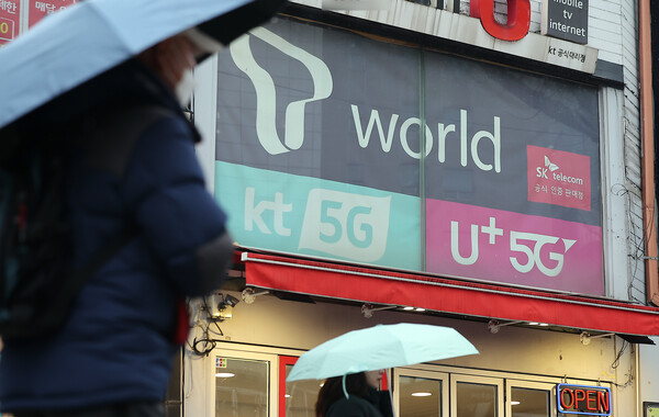 2025년 12월 23일 오후 서울의 한 휴대폰 매장 앞으로 시민이 지나가고 있다. / 뉴스1