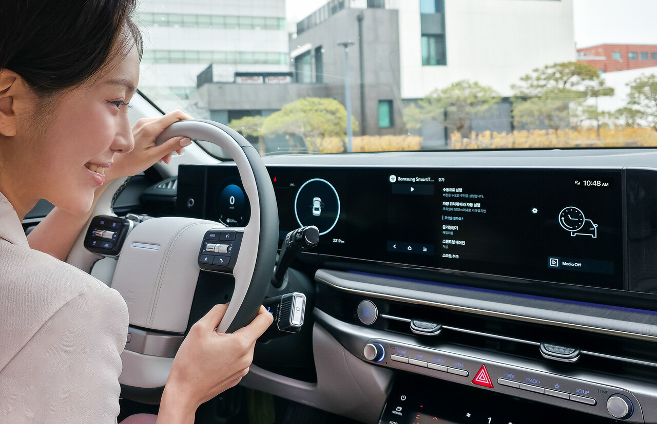 삼성전자 모델이 차량에서 집 안 가전기기를 제어하는 '카투홈(Car-to-Home)' 서비스를 체험하고 있다. / 삼성전자