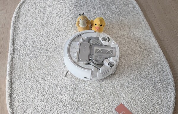 DJI 로모P 로봇청소기가 장애물을 인식해 우회해서 카페트 위를 청소하고 있다. 카드와 인형들을 실시간 인식해 빠르게 회피했다. 