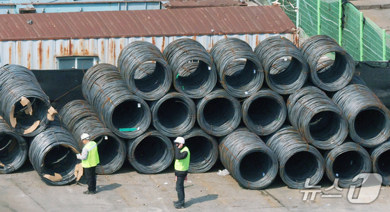 Workers handle steel materials in Asia / Courtesy of News1