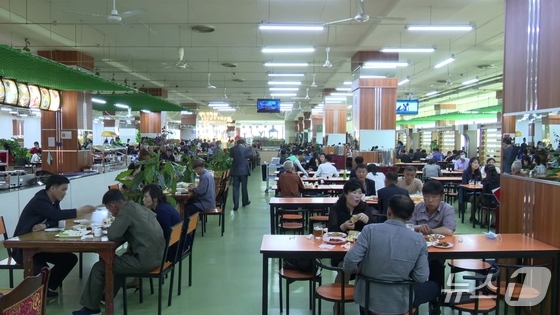 People dining on the third floor of the Kwangbong District Commercial Center, North Korea\'s first large-scale supermarket, which opened in January 2012 / Institute for Peace and Economic Research
