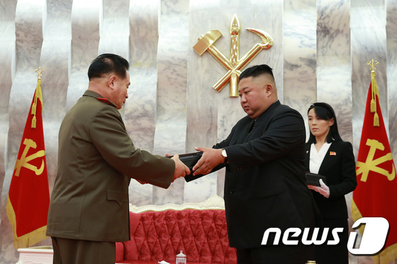 On July 27, 2020, North Korean leader Kim Jong Un presents “Baekdusan” pistols to senior military officials marking the 67th anniversary of “Victory Day” (July 27). Kim Yo Jong, then First Vice Department Director of the Party Central Committee, is clearly visible behind Kim Jong Un. [For Use Only in the Republic of Korea. Redistribution Prohibited] / Courtesy of News1