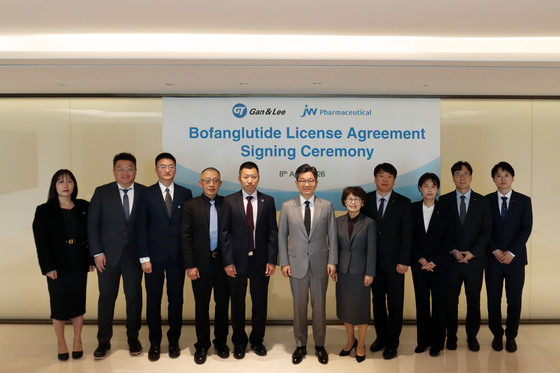 (From the sixth person on the right) Lee Kyung-ha, Chairman of JW, and Wei Chen, Chairman of Gan & Lee Pharmaceuticals, along with executives and employees from both companies, are posing for a commemorative photo / Provided by JW Holdings