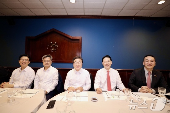 Jang Dong-hyuk (fourth from left), leader of the People Power Party, poses for a photo with Rep. Cho Jung-hoon (from left), Rep. Kim Jang-gyeom, Rep. Kim Dae-sik and Supreme Council member Kim Min-soo during a meeting with Korean correspondents at a restaurant near Washington, D.C., United States, on April 15. (Washington D.C. correspondent pool) 2026.04.15. / Courtesy of News1
