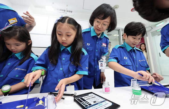 Oh Yoo-kyung, Commissioner of the Ministry of Food and Drug Safety, watches a program demonstration by child ambassadors at the opening ceremony of the Drug Surveillance Center held at KidZania Seoul in Songpa-gu, Seoul / News1