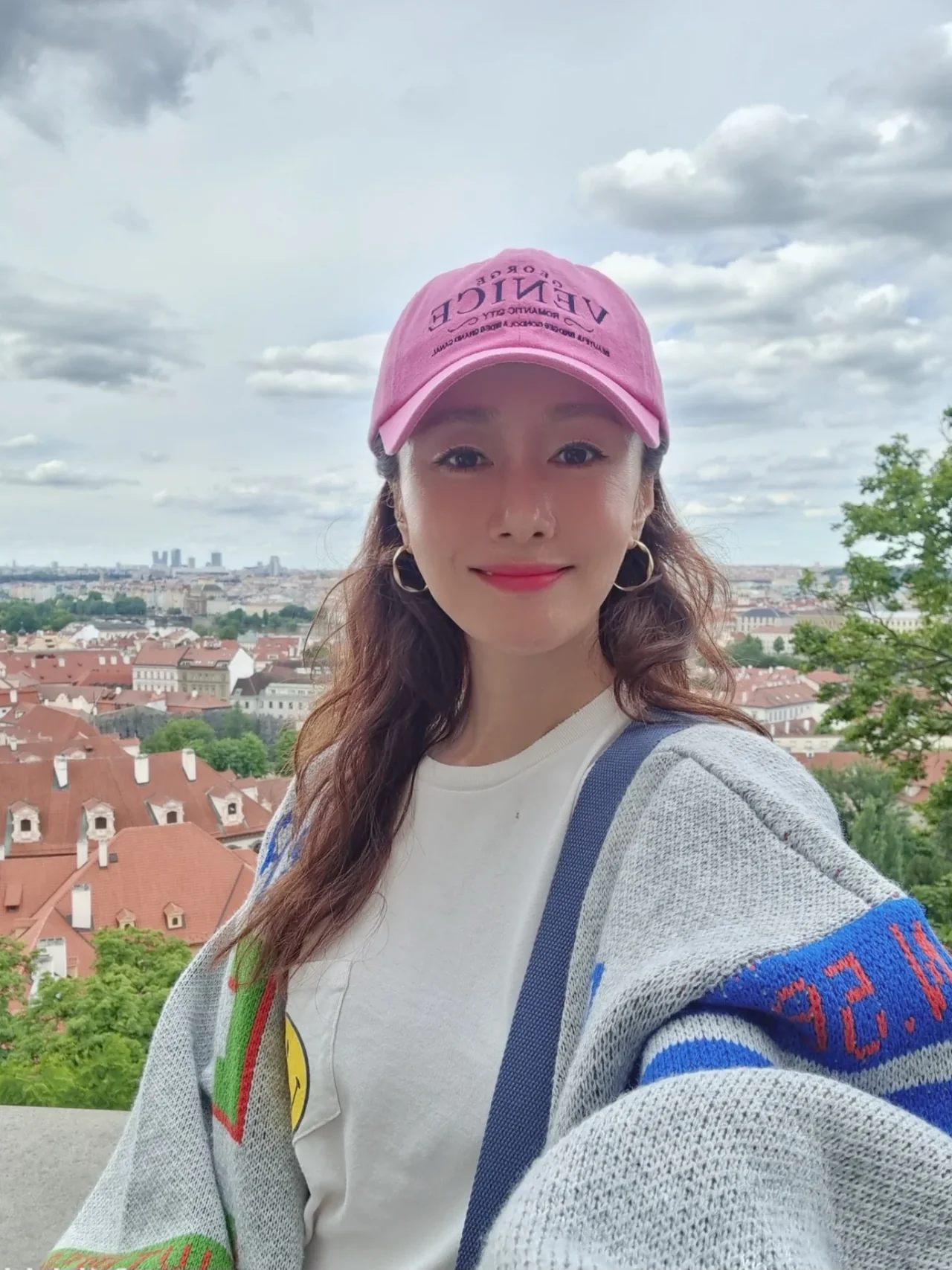 Pink-washed baseball cap + multicolor oversized knit cardigan — Prague travel look / Photo: Kim Ji-soo Instagram (@sooyaaa__)