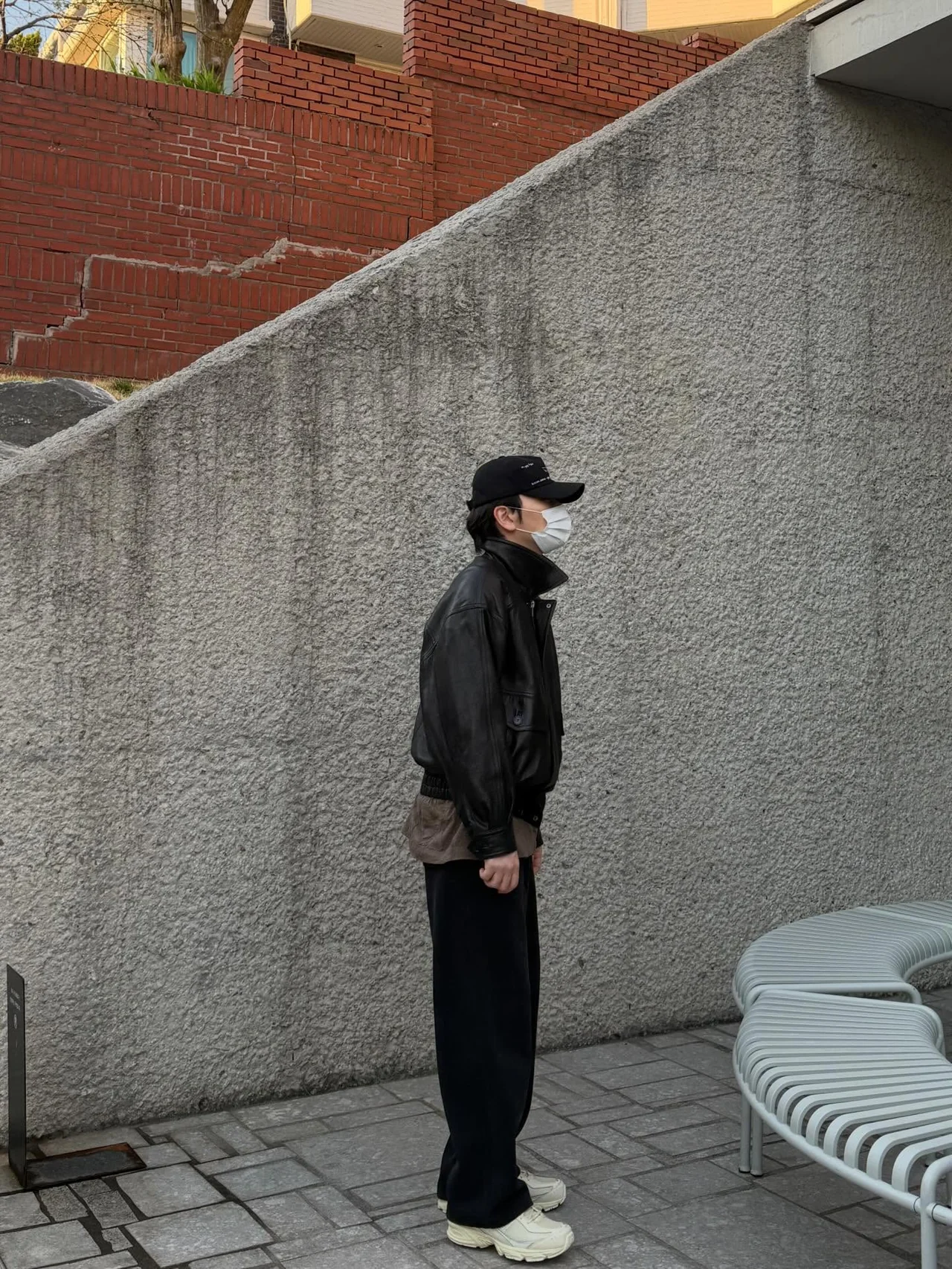 Black leather oversized jacket + black wide pants + black ball cap + cream chunky sneakers — all‑black street look / Photo = Lee Dong‑hwi Instagram (@leedongwhee)