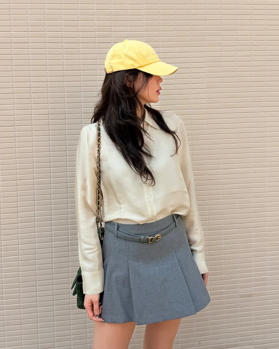 &nbsp;     Ivory satin long-sleeve shirt + gray belted pleated miniskirt + yellow baseball cap, street / Photo: Im Soo-hyang Instagram (@hellopapa11)