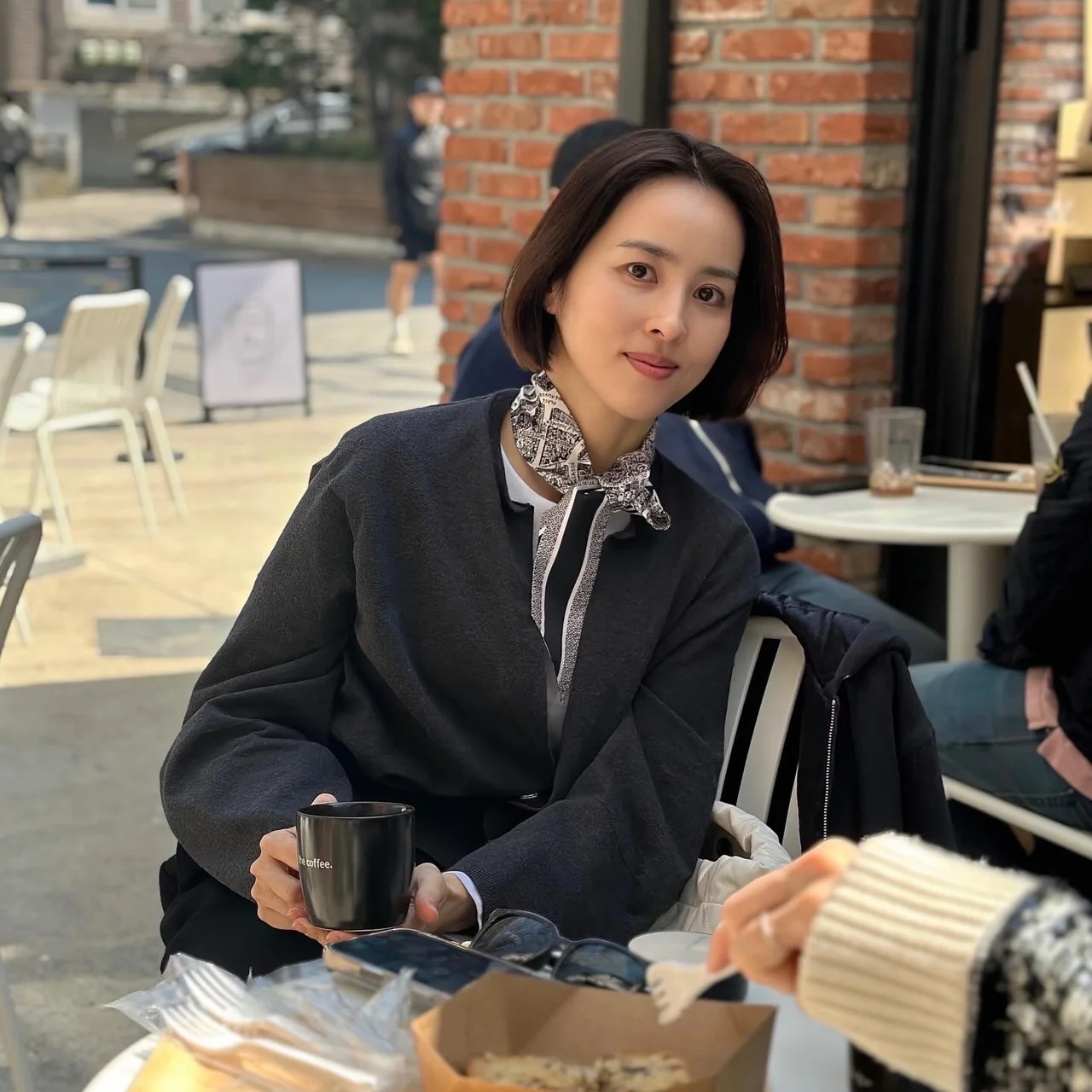 &nbsp;  Black jacket + paisley scarf layering + white quilted shoulder bag on the street / Photo=Han Hye-jin Instagram (@hanhyejin_official)