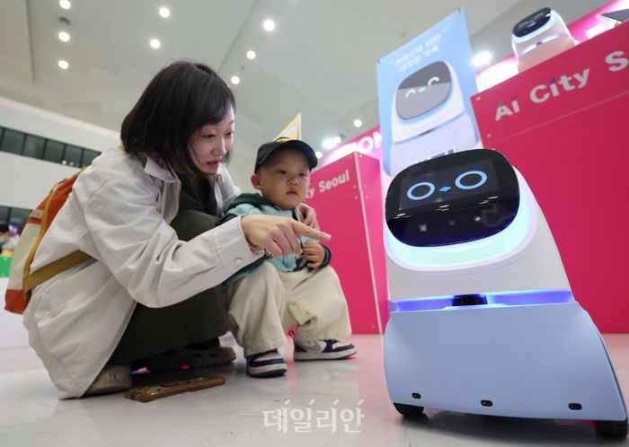 지난 2월 28일 서울 중구 동대문디자인플라자(DDP) 아트홀에서 열린 서울AI페스티벌 2026에서 엄마와 아이가 가정용 생활 반려로봇 ‘케미프렌즈’와 인사하고 있다.ⓒ뉴시스