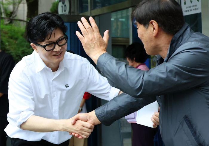 한동훈 국민의힘 전 대표(왼쪽)가 14일 오후 부산 북구 만덕2동 행정복지센터를 찾아 전입신고를 마친 뒤 주민과 인사하고 있다.ⓒ연합뉴스