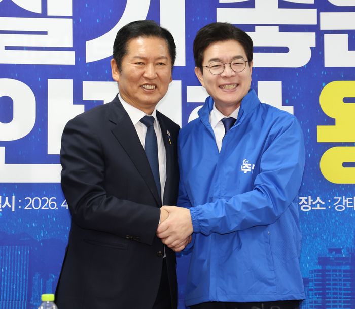 정청래 더불어민주당 대표가 17일 오전 서울 용산구 강태웅 용산구청장 후보 선거사무소에서 열린 현장 최고위원회의에서 정원오 당 서울시장 후보에게 당 점퍼를 입혀준 뒤 악수하고 있다.ⓒ뉴시스