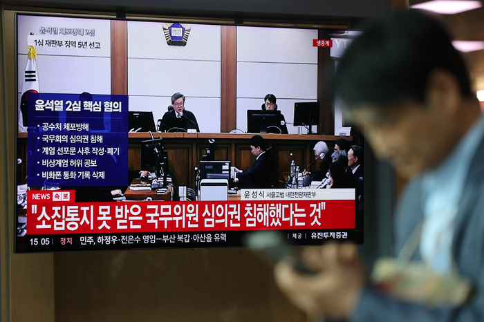 고위공직자범죄수사처 체포방해 등 혐의로 기소된 윤석열 전 대통령의 항소심 선고 공판 생중계 방송이 29일 서울역 대합실 TV를 통해 송출되고 있다. 연합뉴스