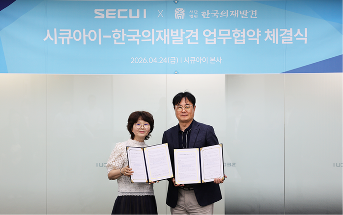 시큐아이 김태욱 상무(우측)와 한국의 재발견 서경서 부대표가 시큐아이 본사에서 업무협약서를 들어보였다.