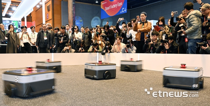 아시아 대표 제조 혁신 전시회 '2026 스마트공장·자동화 산업전(AW 2026)'이 4일 서울 강남구 코엑스에서 열렸다. 참관객이 현대무벡스의 자율주행기반 물류 자동화 로봇의 군집 운행 시연을 살펴보고 있다.  이동근기자 foto@etnews.com