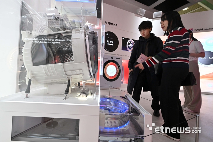 국내 최고 정보통신기술(ICT) 축제 '월드IT쇼 2026'이 22일 서울 강남구 코엑스에서 열렸다. LG전자 부스에서 관람객이 AI 세탁기를 살펴보고 있다. 김민수기자 mskim@etnews.com