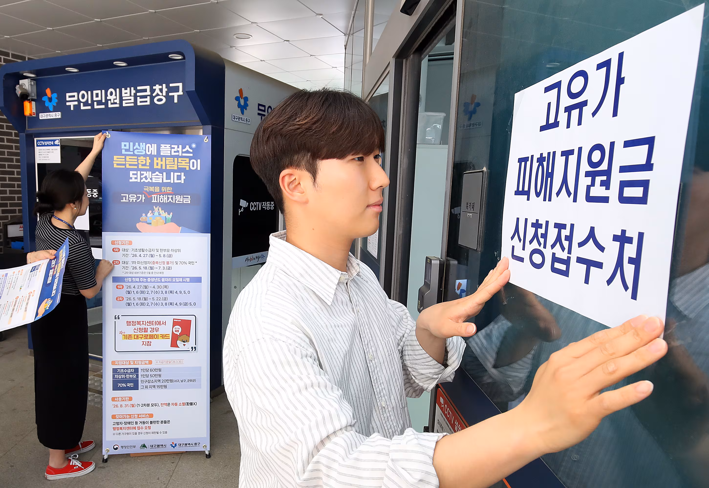 지난 24일 대구 중구 성내3동 행정복지센터에서 직원들이 안내문을 붙이고 있다. /뉴스1