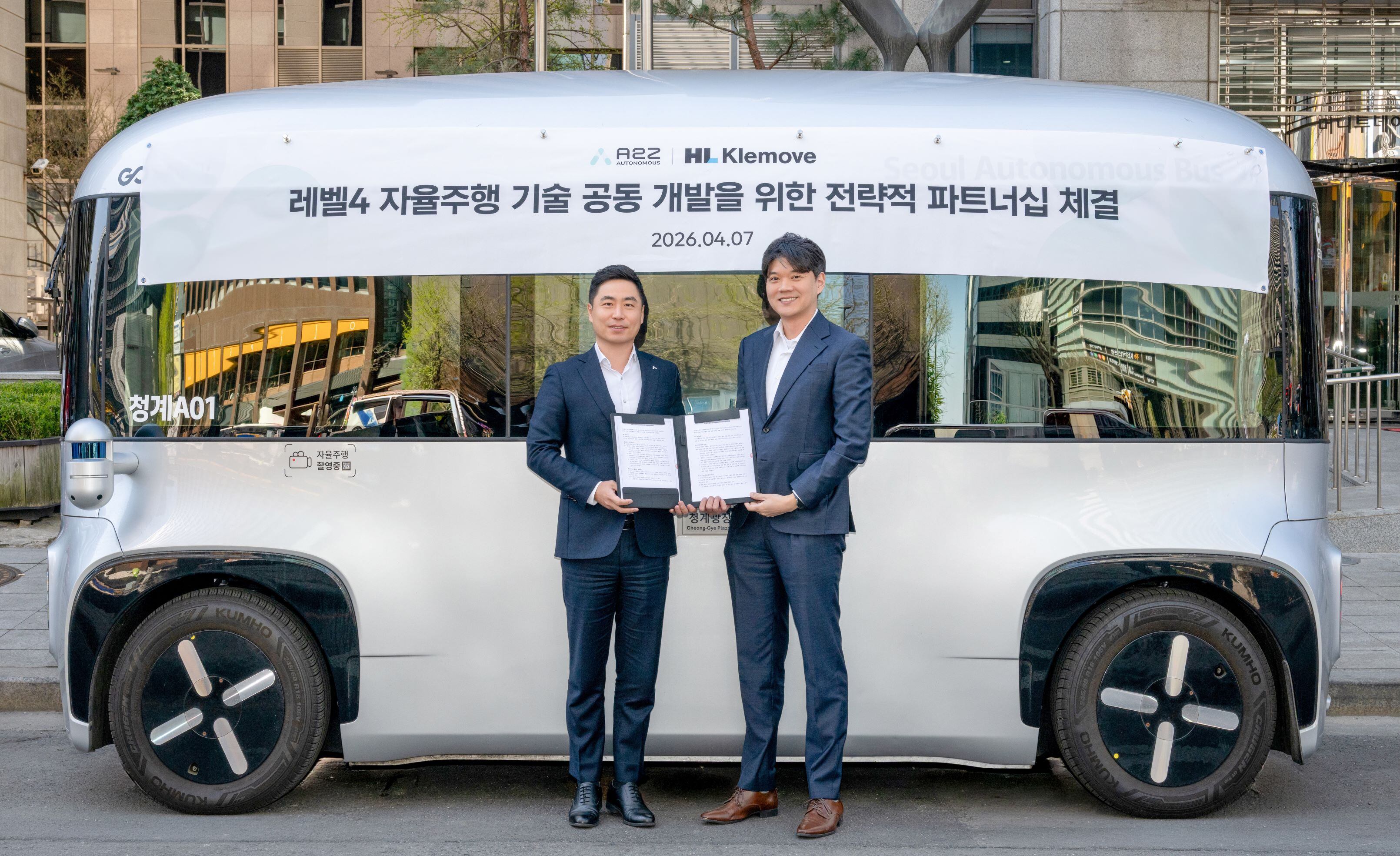 지난 7일 서울 청계광장에서 열린 레벨4 자율주행 기술 공통 개발을 위한 전략적 파트너십 체결식에서 이윤행(오른쪽) HL클레무브 사장과 에이투지 한지형 사장이 자율주행 셔틀 '로이(ROii)' 앞에서 기념 촬영하고 있다. /HL클레무브 제공