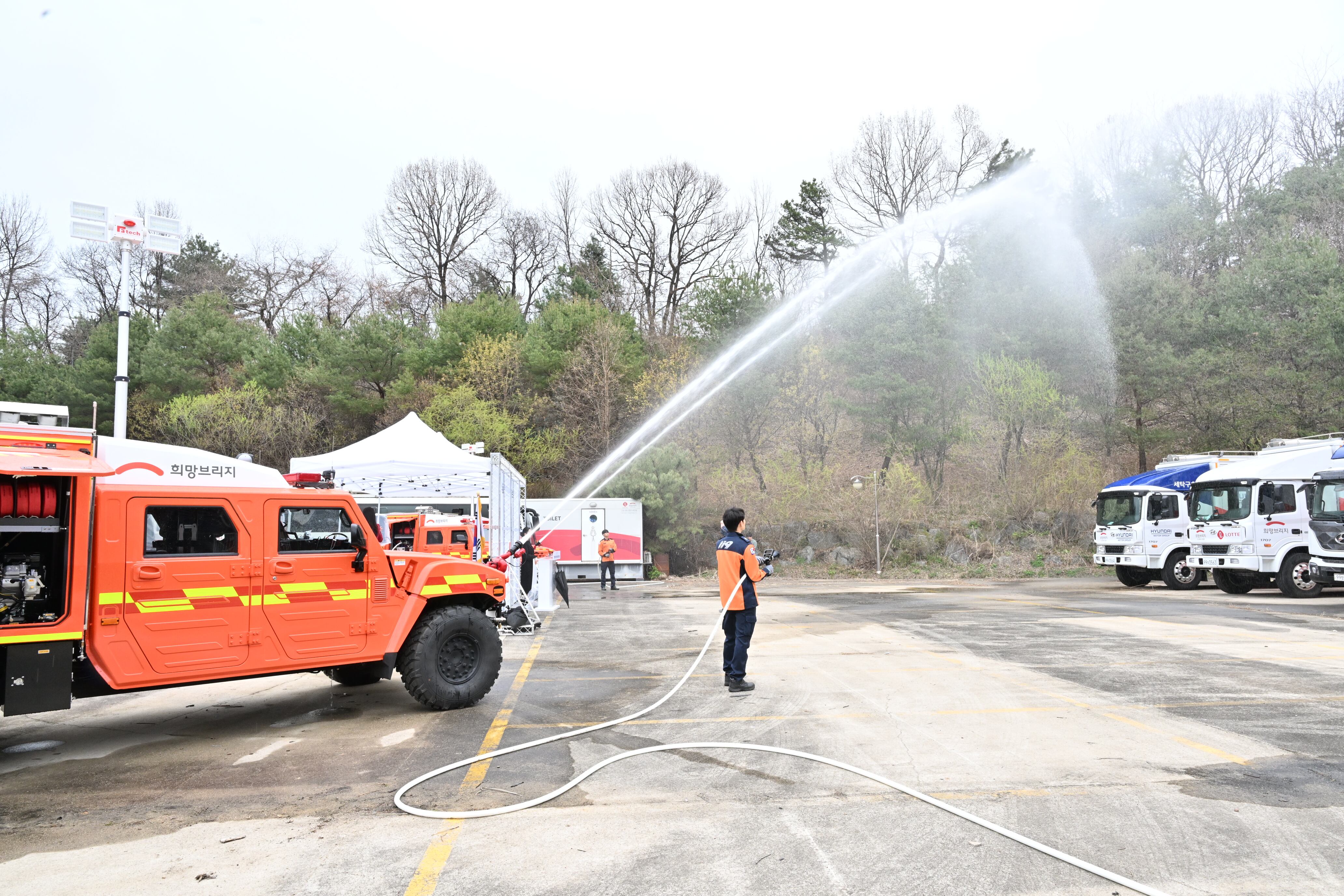 중형 산불진화차가 산악지대 화재 상황을 가정해 산을 향해 물을 뿌리고 있다. /소방청 제공