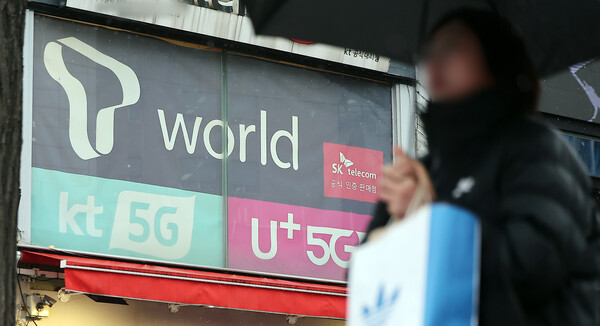 2025년 12월 23일 오후 서울의 한 휴대폰 매장 앞으로 시민이 지나가고 있다. / 뉴스1