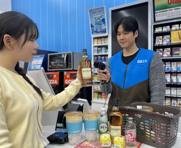 GS25에서 모델이 가성비 위스키 티처스와 하이볼 관련 상품을 구매하고 있다. / GS25