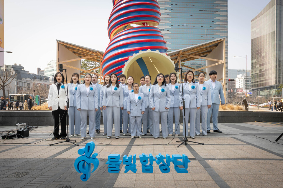 &nbsp;   코웨이 물빛합창단이 지난달 26일 서울 중구 청계광장에서 봄맞이 야외 버스킹 공연을 펼치고 있다. [코웨이 제공]