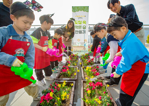 KT 광화문 어린이집 원아와 학부모들이 빌딩 옥상에서 식물 심기와 텃밭을 가꾸는 '옥상 숲 만들기' 프로그램을 진행하는 모습. [사진: KT]