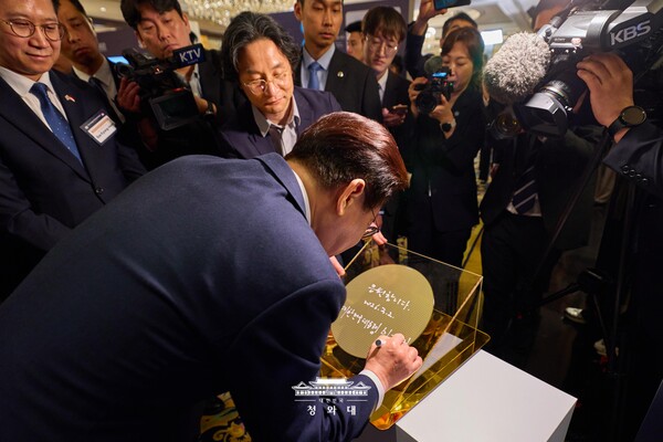 이재명 대통령이 이재명 대통령이 지난달 열린 한-싱가포르 AI 커넥트 서밋 애프터 행사에서 AI 반도체 웨이퍼에 사인하고 있다. [사진: 청와대]