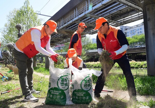 김성수 SK브로드밴드 사장(오) 등 임직원들이 24일 도림천 일대에서 환경 정화 및 생태계 복원을 위한 자원 봉사 활동을 진행했다. [사진: SK브로드밴드]