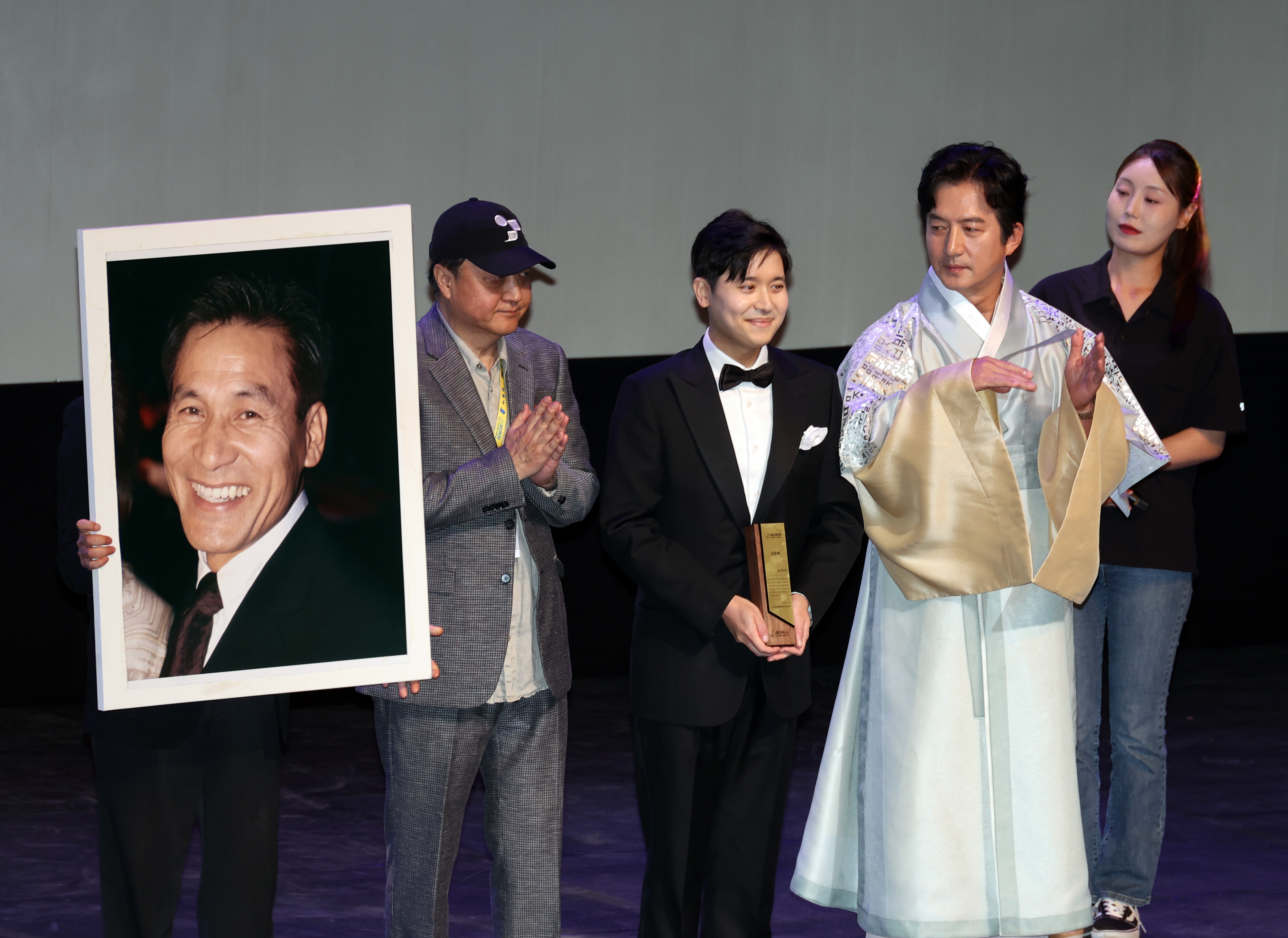  29일 전북 전주시 한국소리문화의전당 모악당에서 열린 제27회 전주국제영화제 개막식에서 조직위원회가 고 안성기 배우에게 특별공로상을 시상하고 있다. 이 상은 그의 아들 필립씨(왼쪽 두번째)가 참석해 대리 수상했다