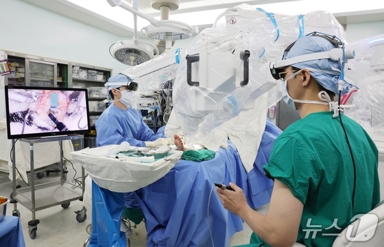 Professor Kwon Jin Geun (right) of Seoul Asan Medical Center performs a lymphaticovenous anastomosis procedure on a patient with lower-limb lymphedema using a supermicrosurgery robot, connecting a lymphatic vessel about 0.4 millimeters wide to a vein. / Courtesy of Seoul Asan Medical Center