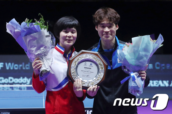 On July 21, 2018, at the Chungmu Gymnasium in Jung-gu, Daejeon, members of the inter-Korean unified team—Jang Woo-jin of South Korea and Cha Hyo-sim of North Korea—are seen smiling brightly while holding their trophy and a bouquet of flowers at the award ceremony following their 3-1 victory over the Chinese national team in the mixed doubles final of the 2018 Korea Open International Table Tennis Championships 2018.7.21 / News1