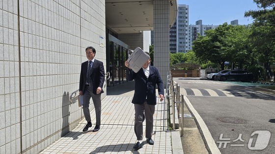 코스닥 상장사 알에프세미 현직 대표 A 씨가 22일 오후 2시 서울남부지법 영장실질심사에 출석하며 얼굴을 가리고 있다./뉴스1 ⓒ News1 윤주영 기자