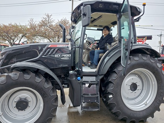 Park Sang-beom, the first customer to purchase an AI tractor, is posing for a commemorative photo / Provided by Daedong