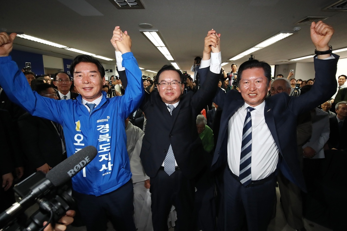김부겸 더불어민주당 대구시장 후보(가운데)가 지난달 26일 대구 달서구 선거사무소 개소식에서 정청래 대표(오른쪽), 오중기 경북도지사 후보와 손을 들어 보이고 있다. / 뉴스1